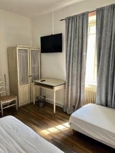 una camera da letto con scrivania, letto e finestra di Chez Marco a La Gouesnière