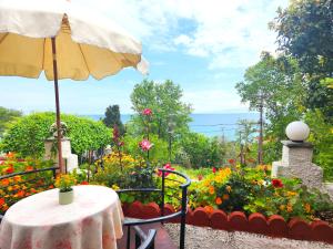 uma mesa com um guarda-sol num jardim com flores em Yalla Chorefto - Hotel & Fun em Chorefto