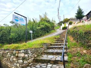 un ensemble de marches en pierre sur une colline avec un panneau dans l'établissement Yalla Chorefto - Hotel & Fun, à Chorefto