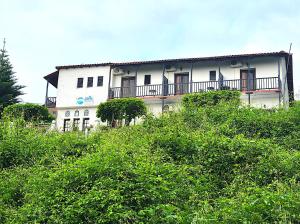 um edifício branco com uma varanda no topo de uma colina em Yalla Chorefto - Hotel & Fun em Chorefto