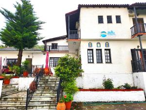 un edificio blanco con escaleras y un árbol en Yalla Chorefto - Hotel & Fun en Chorefto
