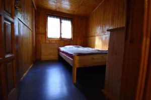 a small bedroom with a bed and a window at Domek u Justy. in Pojezierze