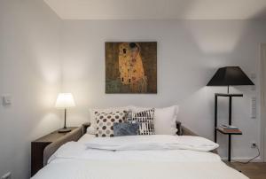 - une chambre avec un lit blanc et une peinture murale dans l'établissement Charming Apartment Close to Heart of Hamburg, à Hambourg