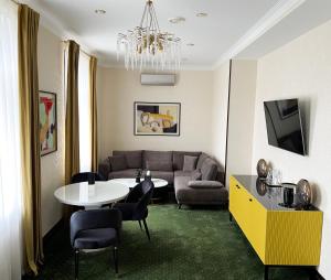 a living room with a couch and a table and chairs at Arcadia Plaza Hotel in Odesa