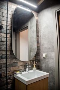 uma casa de banho com um lavatório branco e um espelho. em Ambient Living em Preveza