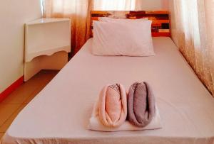 a bed with two pink towels on top of it at RedDoorz @ Jmalls Island Tourist Inn Dinagat Island in Odok