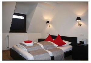 2 bedden in een hotelkamer met rode kussens bij Rheinländer Seehotel in Leverkusen