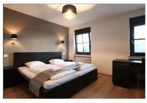 een slaapkamer met een groot bed met witte kussens bij Rheinländer Seehotel in Leverkusen