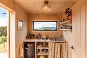una pequeña cocina con fregadero y ventana en Luxury yurt glamping at Littlegrove, en Adventure Bay