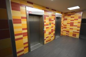 a hallway with colorful tile walls and elevators in a building at Apartment Isabella in Berlin