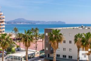 Blick auf den Strand von einem Gebäude mit Palmen in der Unterkunft Apartamento Apolo XVI 1 17 - Grupo Turis in Calpe