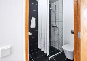 uma casa de banho com um chuveiro e um WC. em Nyborg Strand Hotel & Konference em Nyborg