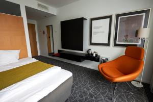 een hotelkamer met een bed en een stoel bij Nyborg Strand Hotel & Konference in Nyborg