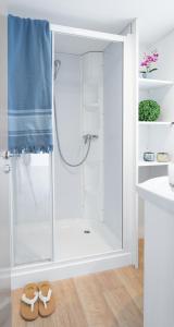 a bathroom with a shower with a pair of slippers at Camping Atlanta & Mediterraneo Family Village in Sottomarina