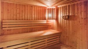 a wooden sauna with a wooden bench in it at Apartamenty Sun & Snow Parkur in Sopot