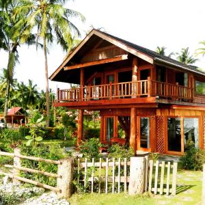 uma casa de madeira com uma cerca em frente em Mentawai Balcony em Masokut