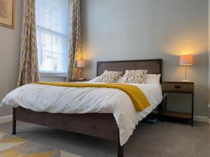 a bedroom with a large bed with a yellow blanket at Bristol Old City Studio in Bristol