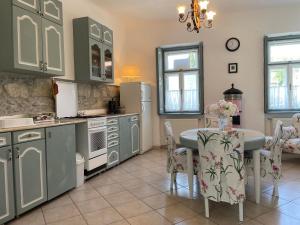 Kánya Veranda في Szomolya: مطبخ مع طاولة وطاولة وكراسي