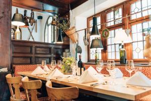 a restaurant with long tables and chairs and windows at AKZENT Hotel Berg's Alte Bauernschänke- Wellness und Wein in Rüdesheim am Rhein