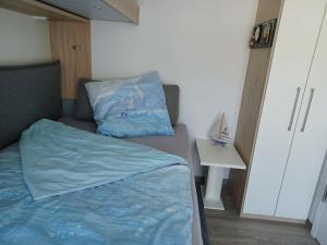 um pequeno quarto com uma cama com um edredão azul em FeWo Am Meer Prora em Binz