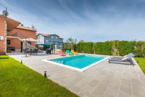 a swimming pool in the backyard of a house at Holiday Home Dori in Fažana