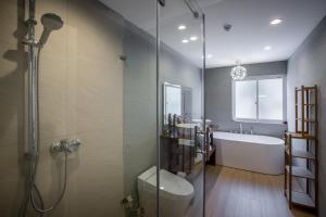 a bathroom with a shower and a toilet and a tub at Chalet Hakuba in Hakuba +32 photos