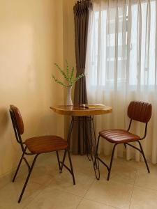 uma mesa e duas cadeiras e uma mesa com uma planta sobre ela em H&A Homestay - 40m, New Built, Center Location, Quiet Place, Full Facilities em Hanói
