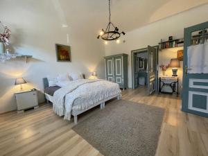 a bedroom with a bed with a white bedspread at Kánya Veranda in Szomolya