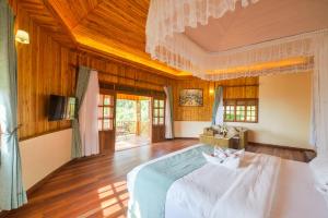 a bedroom with a large white bed in a room at Parkview Safari Lodge-Kyambura in Busonga