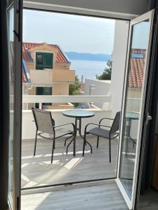 a patio with a table and chairs on a balcony at Apartmani Jukanovic in Baška Voda