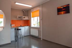 una cucina con pareti bianche e arancioni e un bancone di Haapsalu Kutsehariduskeskuse hostel a Haapsalu