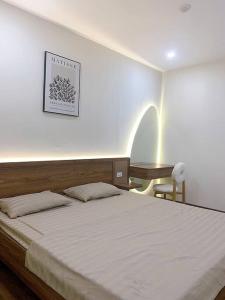 ein Schlafzimmer mit einem großen Bett und einem Schreibtisch in der Unterkunft Căn hộ 2BR trung tâm thành phố view vịnh tuyệt đẹp in Hạ Long