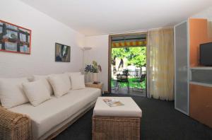 uma sala de estar com um sofá branco e uma mesa em Appartamento Romantica 35 em Raffa