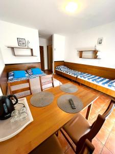 a room with a table and a room with beds at Relax in Niechorze