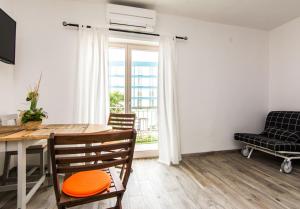 d'une salle à manger avec une table, des chaises et une fenêtre. dans l'établissement Apartments Jankovic, à Biograd na Moru