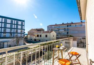 a balcony with two chairs and a table on a balcony at Apartments Jankovic in Biograd na Moru