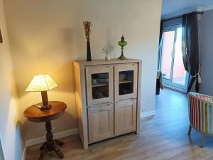 a room with a cabinet and a lamp and a table at Appartement Dreux in Dreux