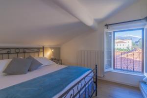 um quarto com uma cama e uma grande janela em La Baia by Wonderful Italy em Bellagio