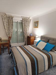 um quarto com uma cama, uma secretária e uma janela em Appartement Dreux em Dreux
