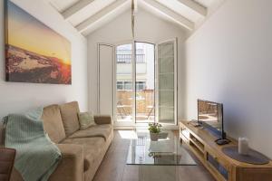 a living room with a couch and a tv at Urbe10 Terrace Constitucion 1 Bedroom Apartment in Málaga