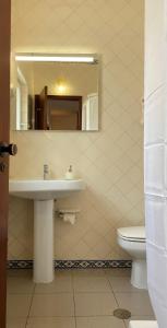 a bathroom with a sink and a toilet and a mirror at Casa do Miradouro in Carrapateira +30 photos
