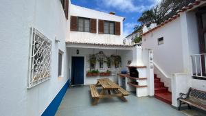 a patio with a wooden bench and a table at Casa do Miradouro in Carrapateira