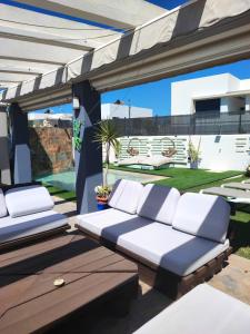 - une terrasse avec 2 lits dans l'établissement Villa chillout la barrosa, à Chiclana de la Frontera