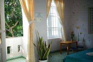 1 dormitorio con cama, mesa y ventanas en Jaymo Motel, en Vung Tau