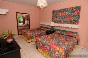 a hotel room with two beds and a mirror at Verney House Resort in Montego Bay