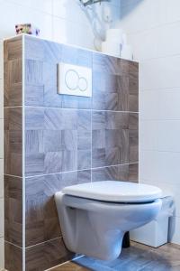 bagno con servizi igienici e parete piastrellata di Gentlemen's Apartment near Brno-Center a Brno