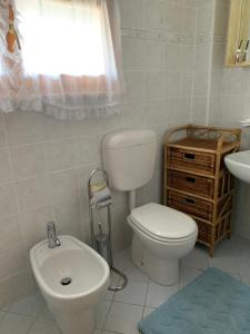 a bathroom with a white toilet and a sink at Appartamento Toscani in Vic +6 photos