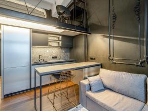 a kitchen with a couch and a table in a room at Stylish Black and White loft in Kaunas
