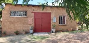 a red door on the side of a house at Leopard Tree Retreat in Nelspruit