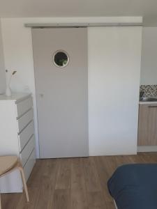 una camera da letto con pareti bianche e una porta con finestra di Chambre d'hôte Milin An Awel a Pleumeur-Bodou